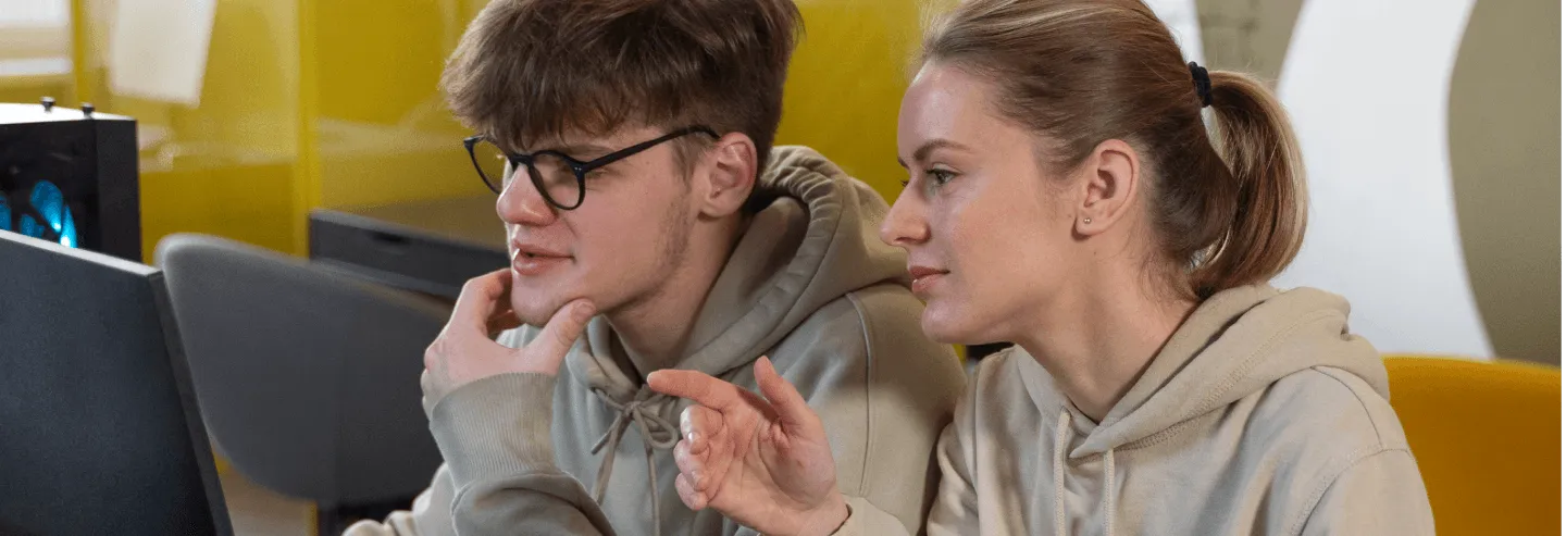 two people looking at monitor screen